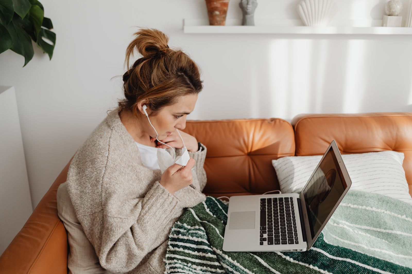 Donna segue un colloquio psicologico online in videochiamata dal divano di casa